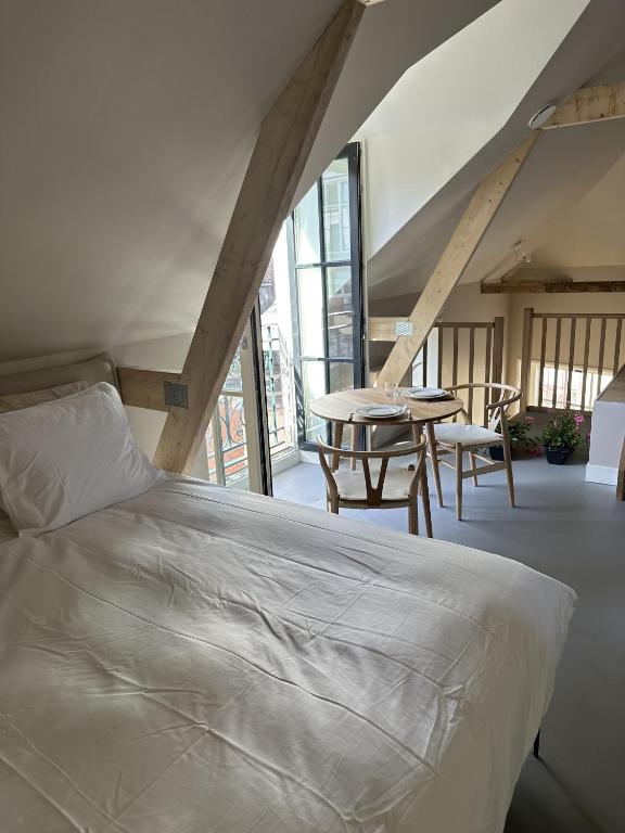 a bedroom with a bed and a table in a room at Luxe Loft in Historisch Pand in Walstraat Deventer in Deventer