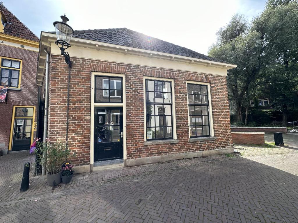 ein Backsteingebäude mit einer schwarzen Tür und Fenstern in der Unterkunft Luxe Loft in Historisch Pand in Walstraat Deventer in Deventer
