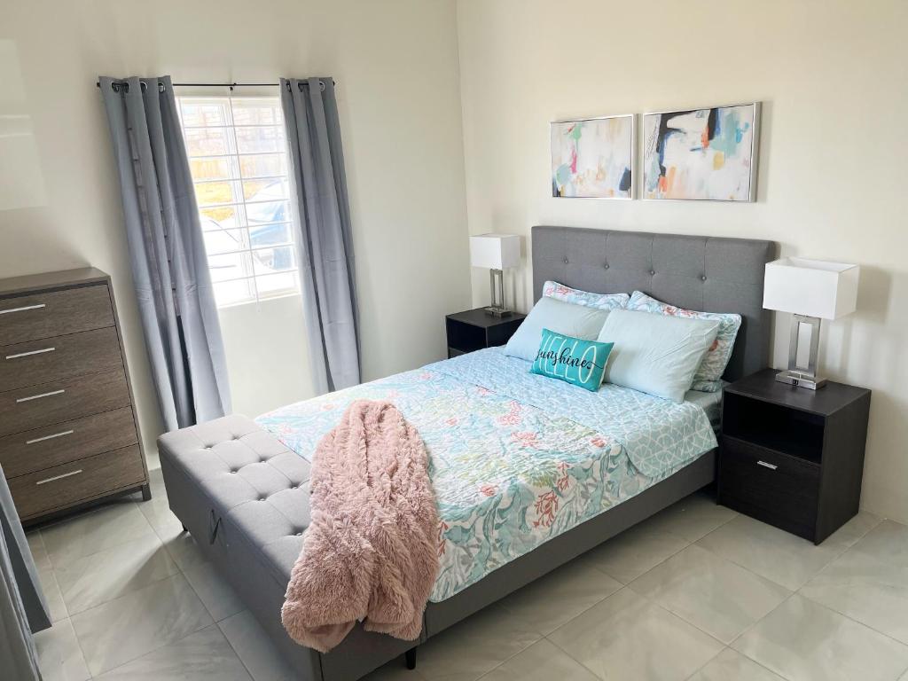 a bedroom with a bed and a window at Yaad Oasis in Discovery Bay