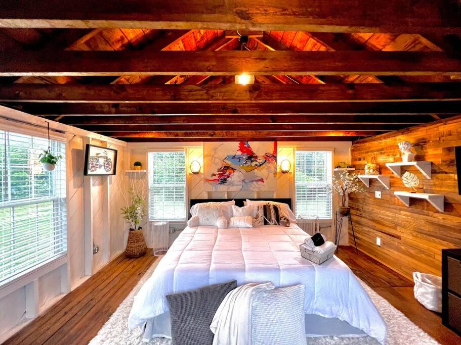 a bedroom with a large bed in a room with wooden ceilings at Tiny House Hideaway with King Bed in Cape Charles