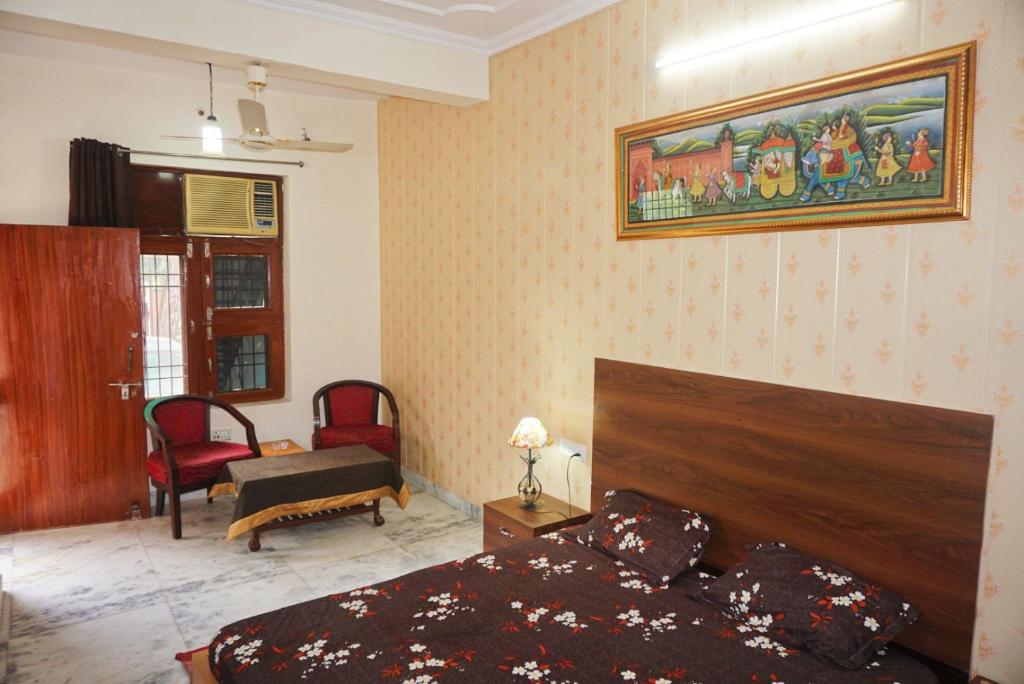 - une chambre avec un lit et une peinture murale dans l'établissement The Nest, à Jaipur