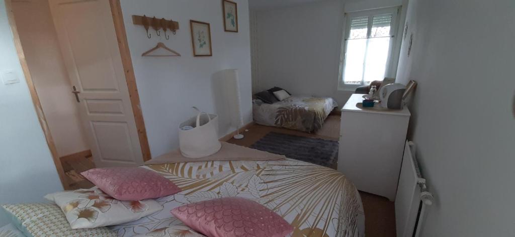 een slaapkamer met een bed en twee kussens erop bij Les chambres du Val d'Eyden 