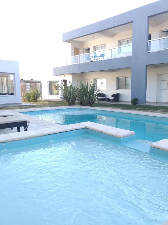 a swimming pool in front of a house at Cala hotel boutique in San Luis