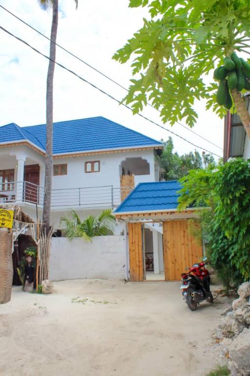 a house with a motorcycle parked in front of it at Pamoja Beach Stays Hotel in Jambiani in Jambiani