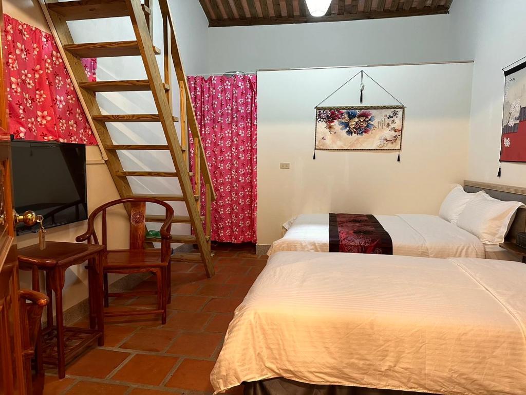 sypialnia z 2 łóżkami i schodami w obiekcie Yong Le Homestay w mieście Jincheng