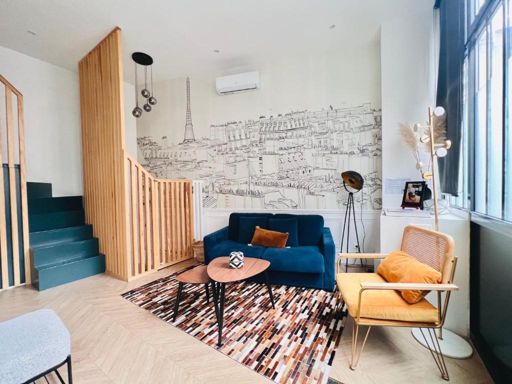 un salon avec un canapé bleu et un dessin mural dans l'établissement Montmartre Marvel! Designer Apartment near metro, à Paris