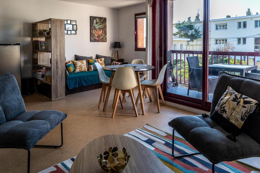 ein Wohnzimmer mit einem Sofa und einem Tisch in der Unterkunft LE DANVIN - Spacieux Studio 4 pers - Grand balcon - A 150 m de la Plage in Berck-sur-Mer