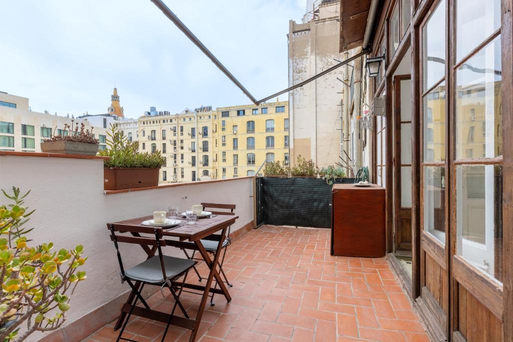 a patio with a table and chairs on a balcony at Lodging Apartments Paseo de Gracia in Barcelona
