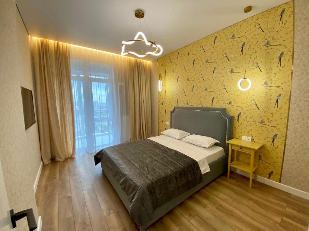 sypialnia z łóżkiem i żółtą ścianą w obiekcie Premium apartment Atlant w mieście Astana