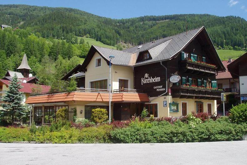 ein großes Gebäude mit einem Schild an der Seite in der Unterkunft Gasthof-Pension Alt Kirchheim in Bad Kleinkirchheim