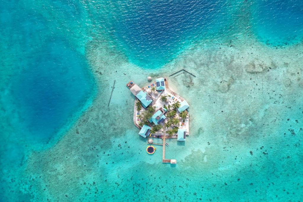 an aerial view of a small island in the ocean at King Lewey's Island Resort in Placencia Village