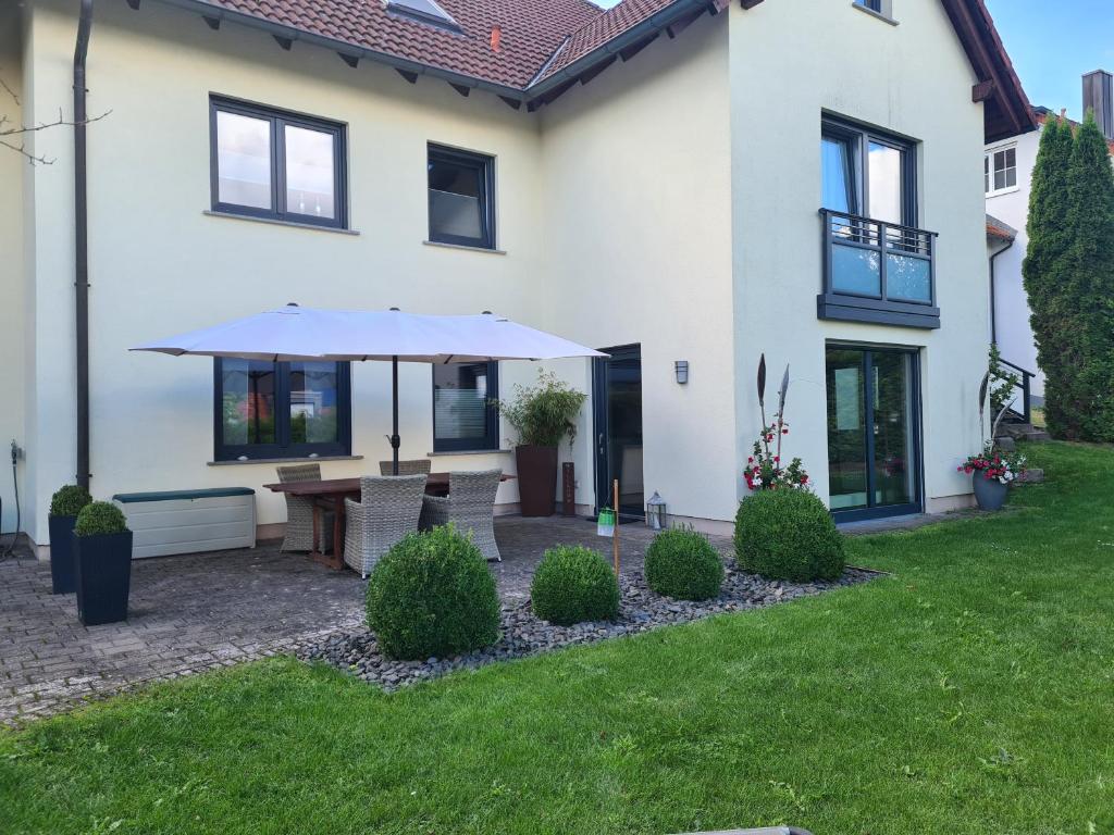 a patio with an umbrella in the yard of a house at Monteurwohnung in Bad Neustadt an der Saale