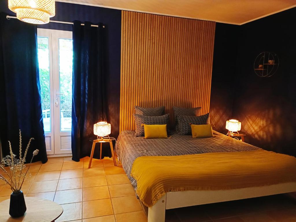 1 dormitorio con 1 cama grande con almohadas amarillas en Chambre d'hôtes de charme, A Nosté M&P en Poussignac