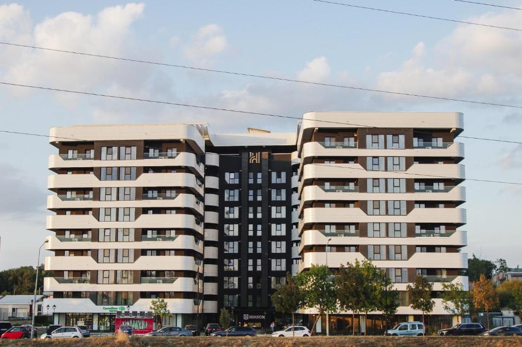 a large apartment building with cars parked in front of it at Himson-Brown Apartment in Iaşi