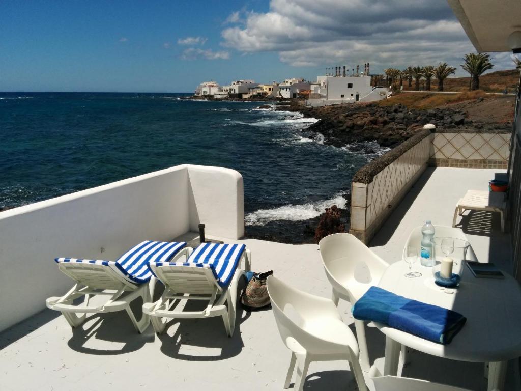 einen Balkon mit Stühlen, einem Tisch und Meerblick in der Unterkunft Villa Caracoles in Costa Teguise