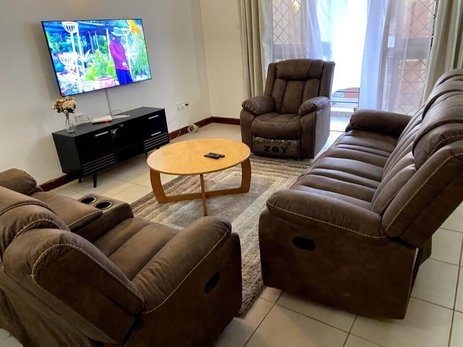 a living room with two couches and a coffee table at Pacho- All en-suite 2br in Kisumu