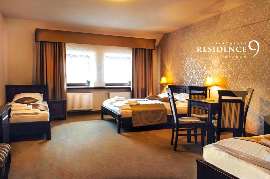 pokój hotelowy z 2 łóżkami, stołem i krzesłami w obiekcie Residence9 w Krakowie
