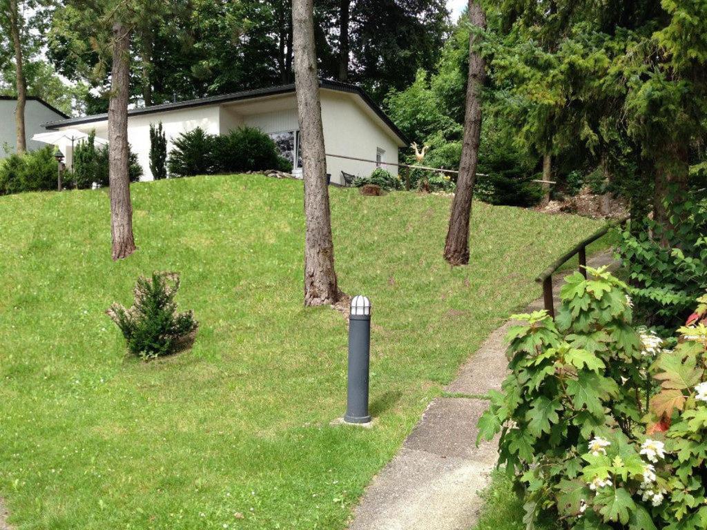 a pole in the grass in a yard with trees at Traumhaftes Ferienhaus in Husen