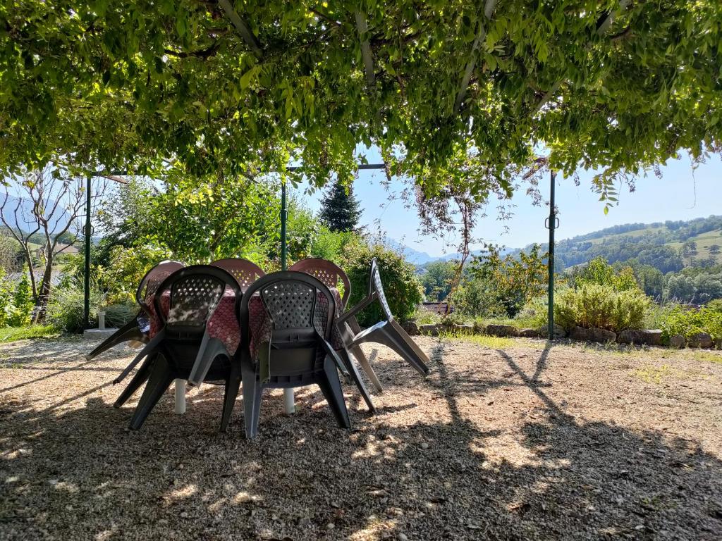 un groupe de chaises assises sous un arbre dans l'établissement Entre Lacs et Montagnes, à Cusy