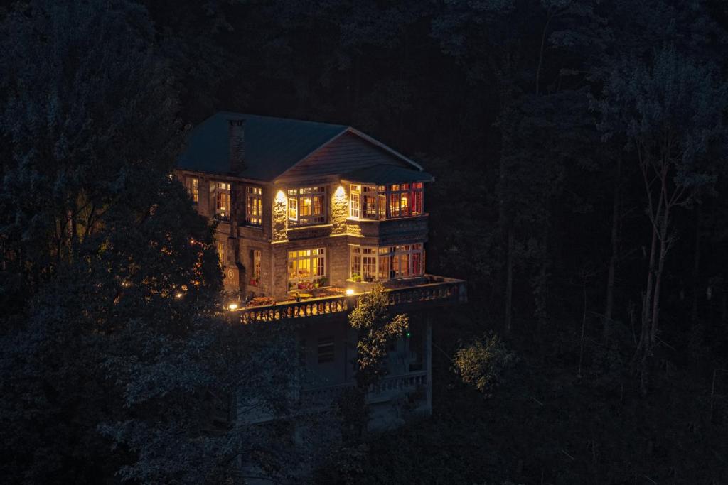 a large house lit up at night with lights at Trippers hostel in Darjeeling