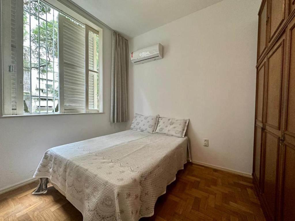 - une chambre avec un lit dans une pièce dotée d'une fenêtre dans l'établissement Amplo & Confortável - Copacabana - Posto 6, à Rio de Janeiro