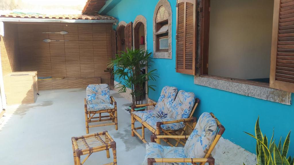 eine Terrasse mit Stühlen und einer blauen Wand in der Unterkunft casa na vila historica in Angra dos Reis