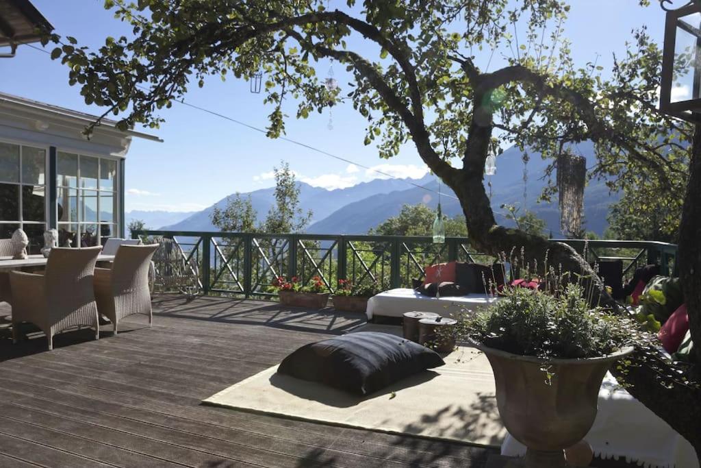 una terraza con mesa y sillas y vistas a las montañas en Exklusives Landhaus in den Bergen, en Arzl im Pitztal