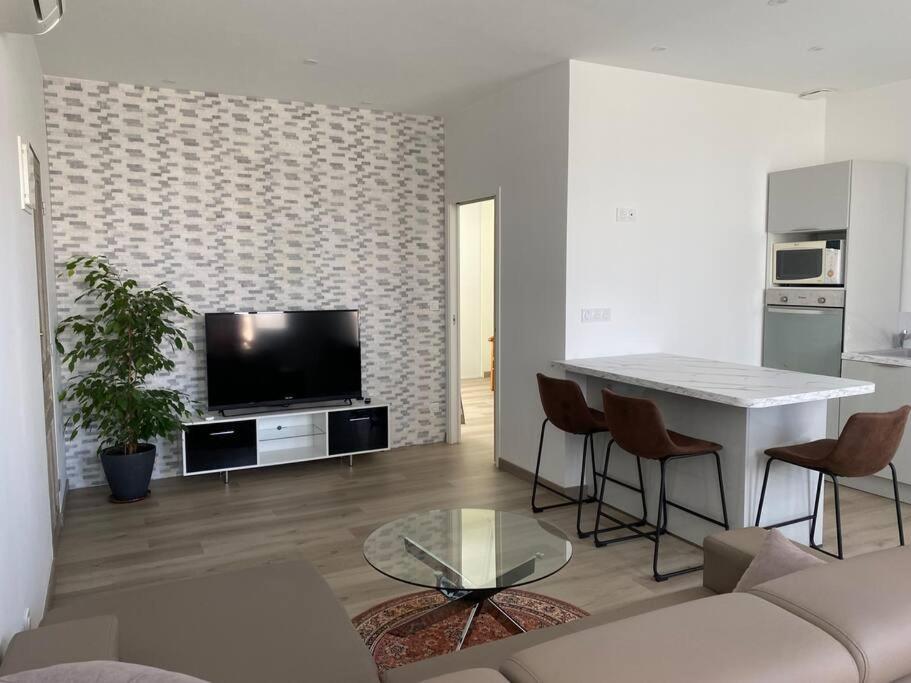 ein Wohnzimmer mit einem Sofa, einem Tisch und einem TV in der Unterkunft Casaromance in Saint-Parres-aux-Tertres