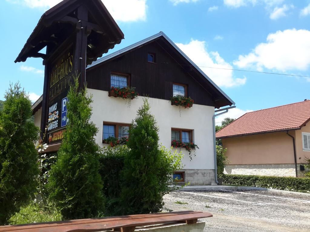 a black and white building with flowers on the windows at Lake House in Jezerce