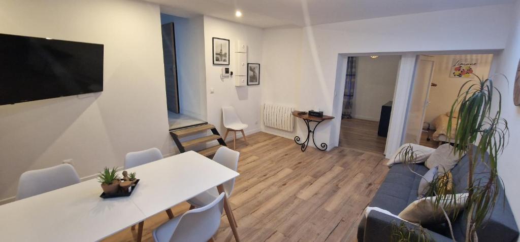 een woonkamer met een witte tafel en stoelen bij Appartement cosy près de Douai in Flers-en-Escribeus
