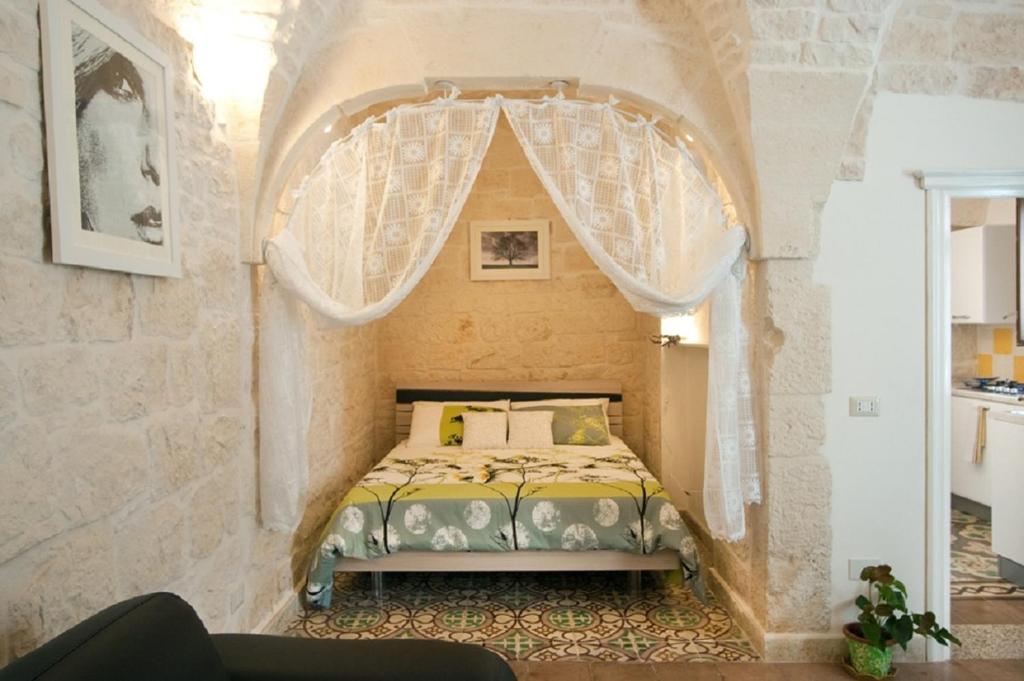 um quarto com uma cama numa parede de pedra em Apartment Mammacara em Ceglie Messapica