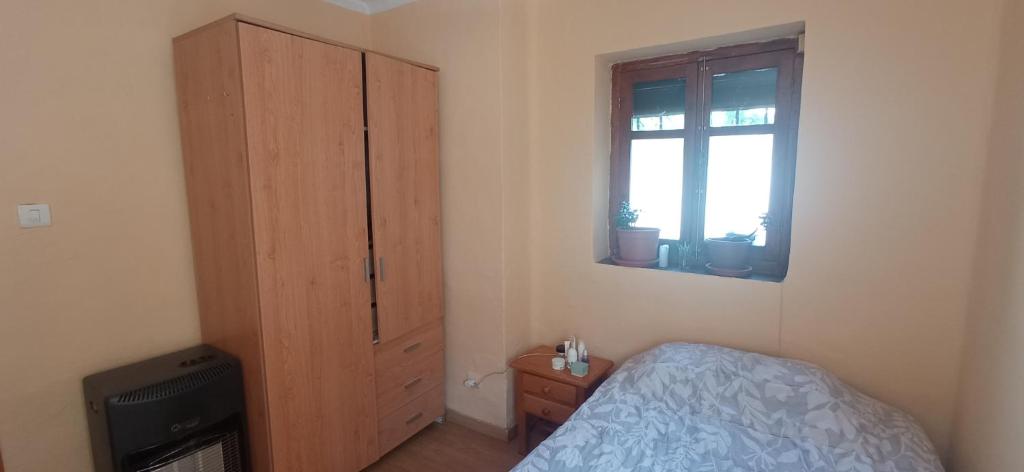 a bedroom with a bed and a cabinet and a window at Comfort Zone in Órgiva