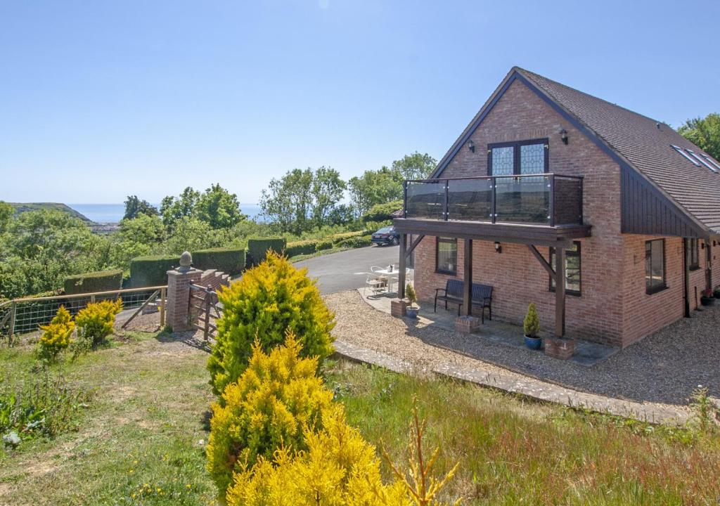 a house with a balcony on the side of it at Holly Cottage in Seaton