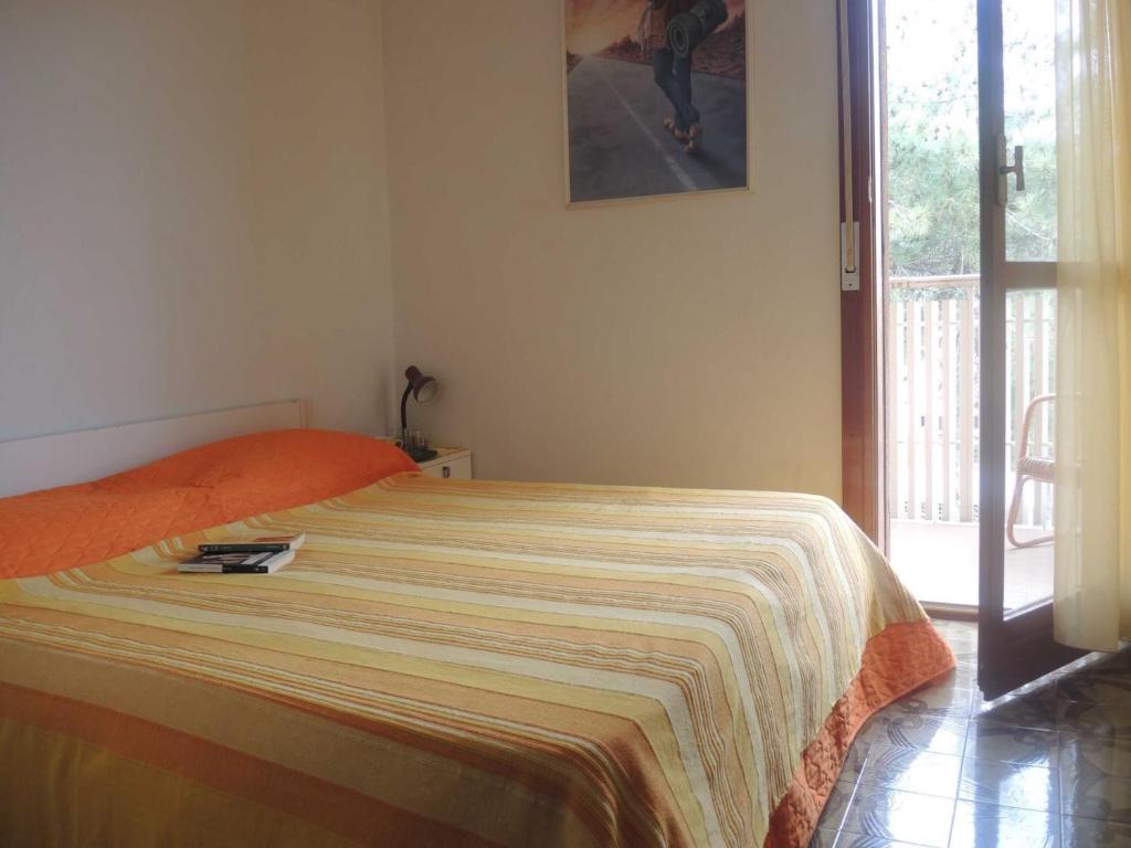 een slaapkamer met een bed met een deken erop bij Comfy&cozy flat next to the beach - Beahost in Bibione