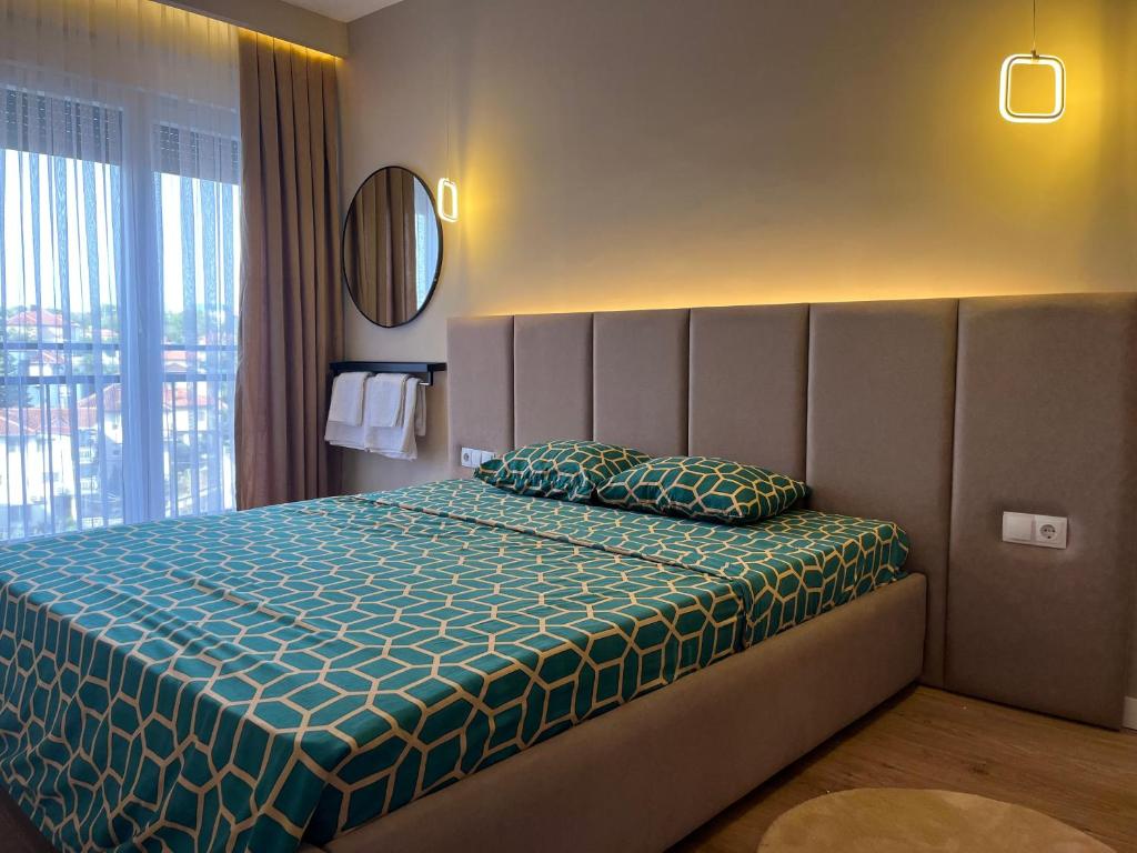 a bedroom with a large bed with a large window at TOP-Apartments in Pristina