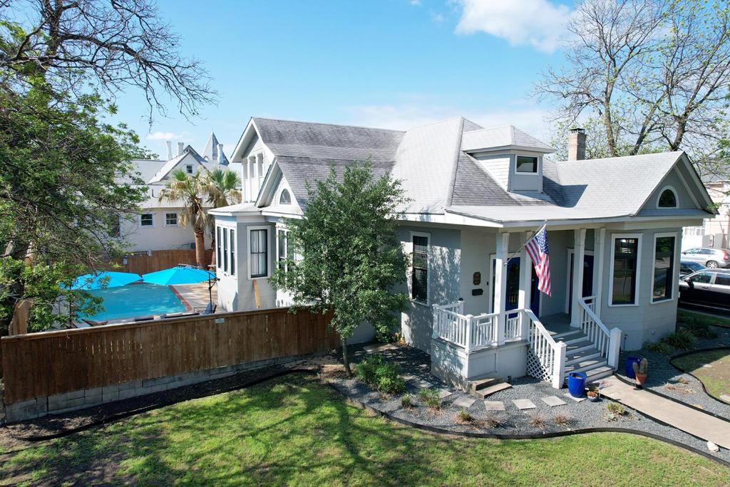 a white house with a flag in front of it at San Antonio gem, spacious home with pool in desirable Monte Vista in San Antonio