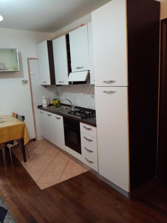 a kitchen with white cabinets and a stove top oven at La Casetta delle Farfalle in Lanciano