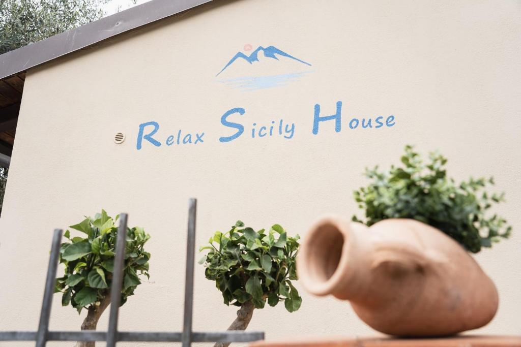 eine Vase vor einem Haus mit Pflanzen in der Unterkunft Relax Sicily House in Savoca 