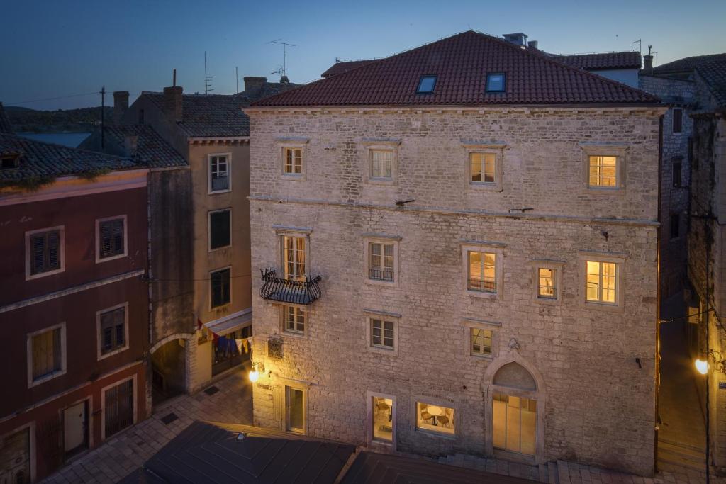 een groot bakstenen gebouw met lichten aan bij Heritage Hotel Life Palace in Šibenik