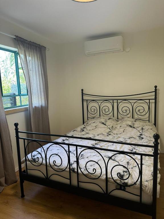 a black bed in a bedroom with a window at רגע מושלם in Shave Ẕiyyon