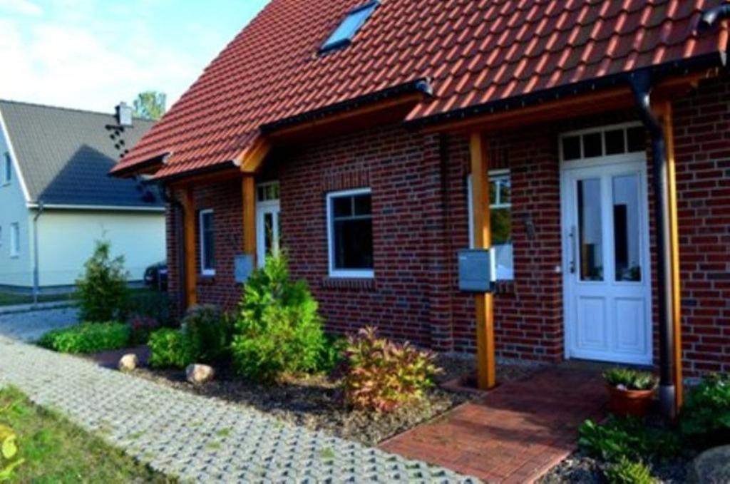 una casa de ladrillo rojo con puerta blanca en Usedom Suites Ückeritz, en Ückeritz