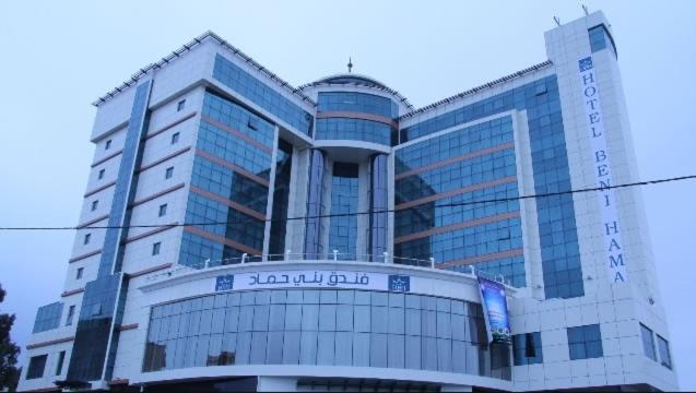 a large building with a sign in front of it at HOTEL BENI HAMAD in Bordj Bou Arreridj