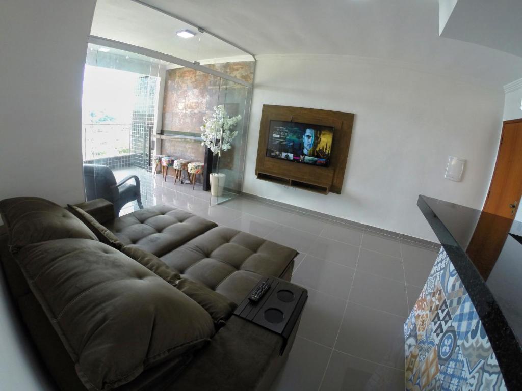 a living room with a couch and a tv at TH Flats GV Shopping 403 in Governador Valadares