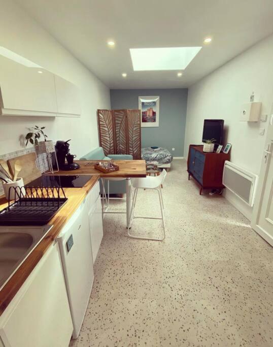 une cuisine et un salon avec une table et un canapé dans l'établissement studio cosy idéalement situé, à Angers