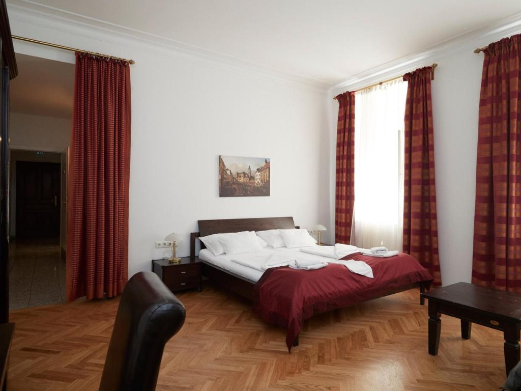 1 dormitorio con 1 cama grande y cortinas rojas en La Scala Apartments, en Viena