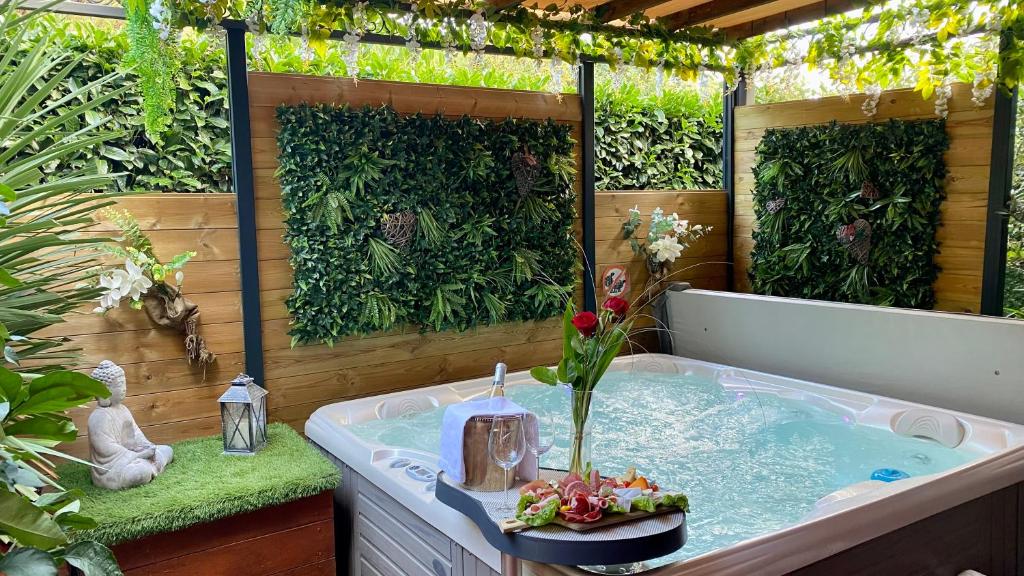 un bain à remous dans un jardin avec des plantes dans l'établissement Un petit coin de Paradis, à Toulouse