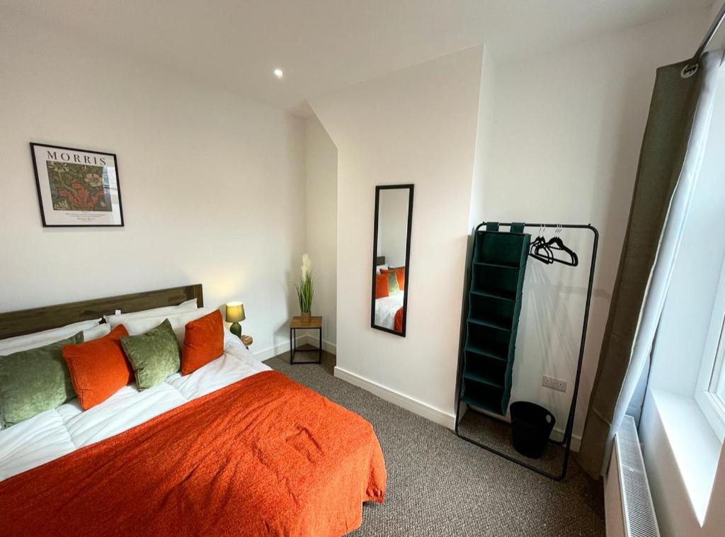 ein Schlafzimmer mit einem orangenen Bett und einem Spiegel in der Unterkunft 38 Gloucester street by Prestige Properties SA in Roose