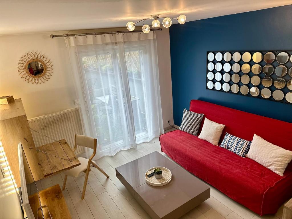 - un salon avec un canapé rouge et un mur bleu dans l'établissement Jasmin étoilé duplex avec jardin 15 min de Paris, à Alfortville