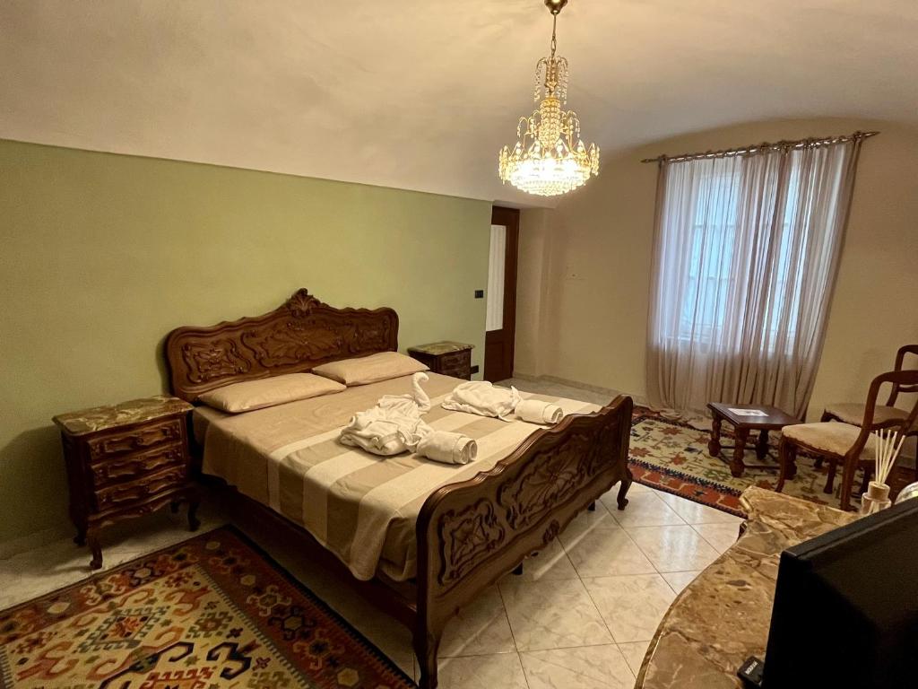 a bedroom with a large bed and a chandelier at Casa dell’Annunziata in Chiusa di Pesio