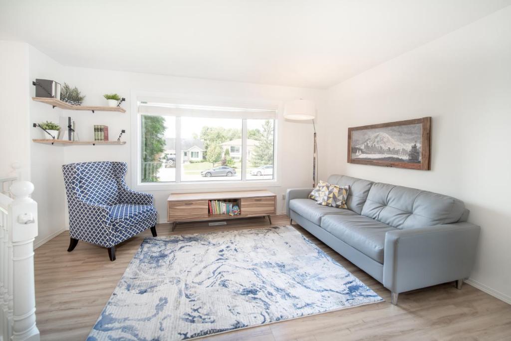 sala de estar con sofá y silla en Bright & Convenient b/w 2 Parks, en Steinbach